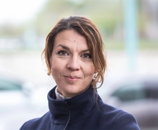 The VERBUND employee wears her mid-brown hair tied up. She has brown eyes and smiles at the camera.