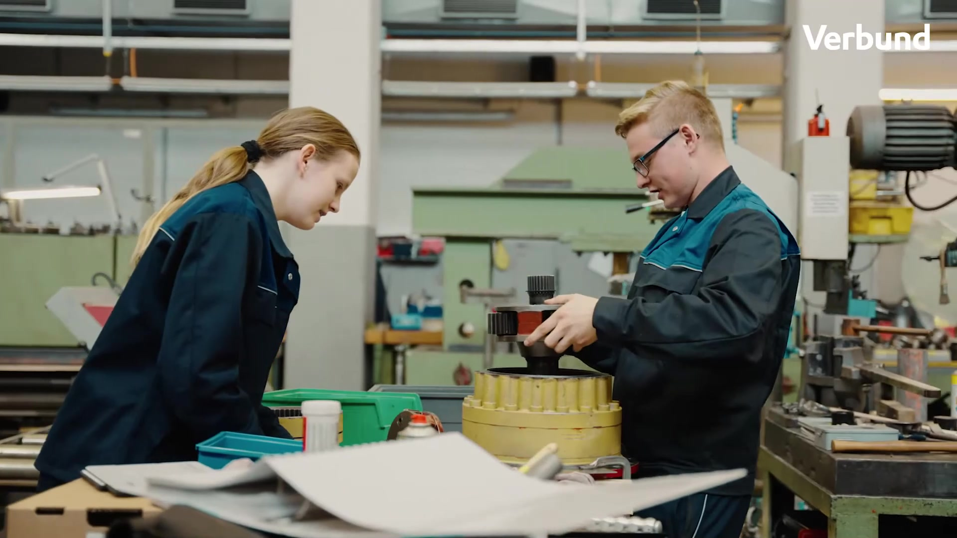 Wir beobachten zwei VERBUND-Mitarbeiter:innen bei der Arbeit in einer Werkstätte.